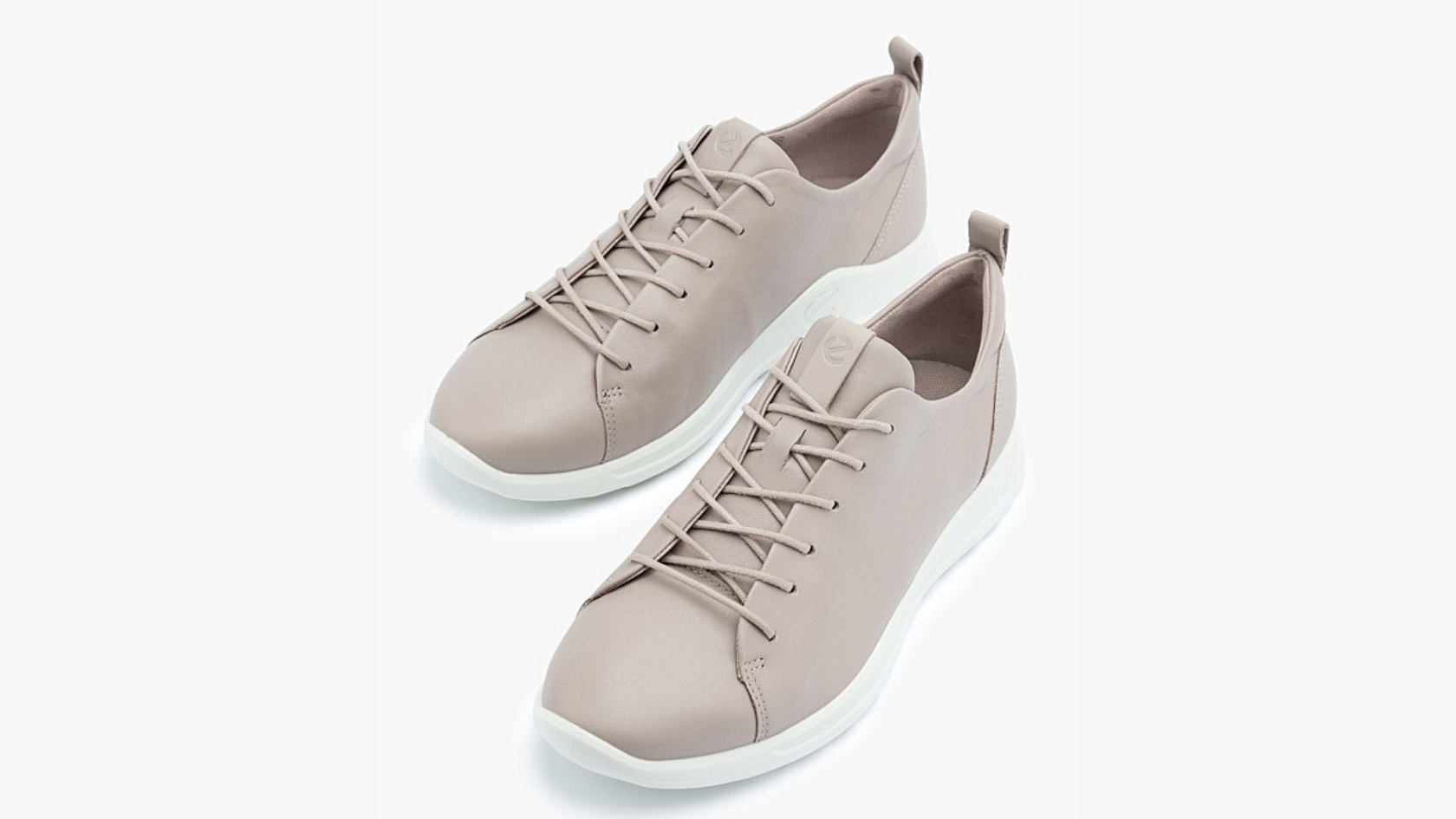 A pair of taupe leather lace-up sneakers against a neutral background.  