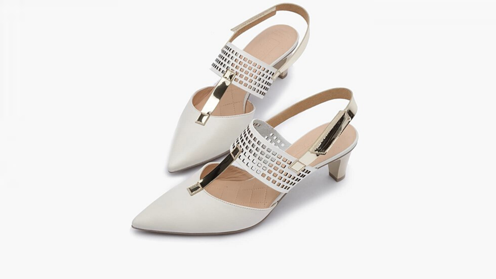 Pair of white pointed toe heels with golden metallic finishings against a neutral background.